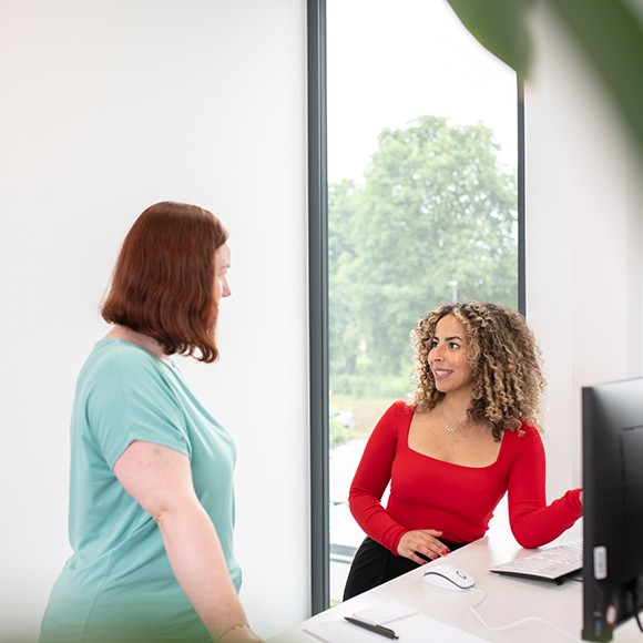 Zwei Personen im Gespräch vor PC