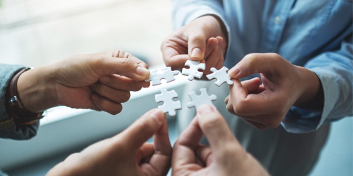 Hands put puzzle pieces together